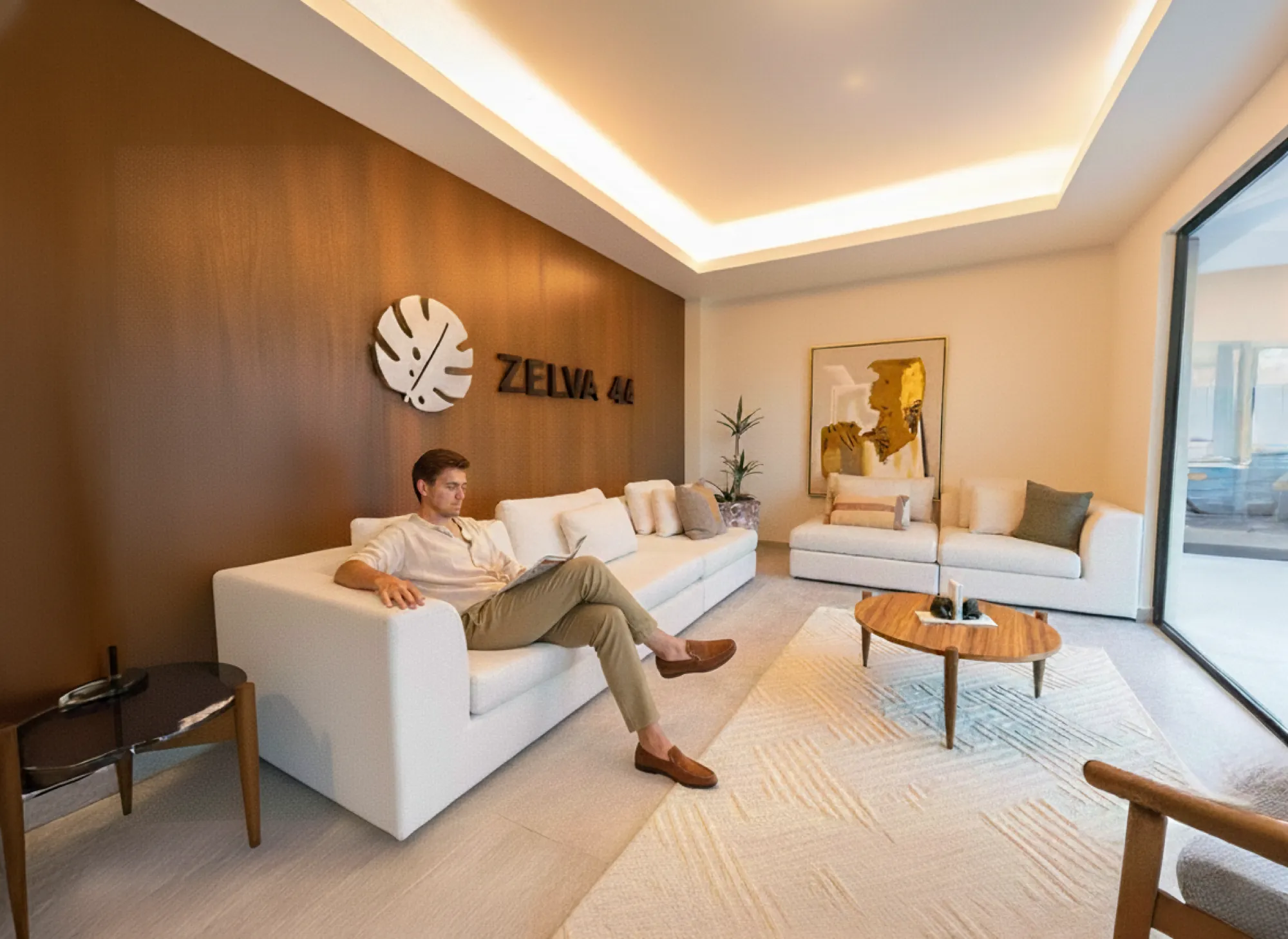 Residente leyendo en el lobby de Zelva44 con muro de madera y logotipo